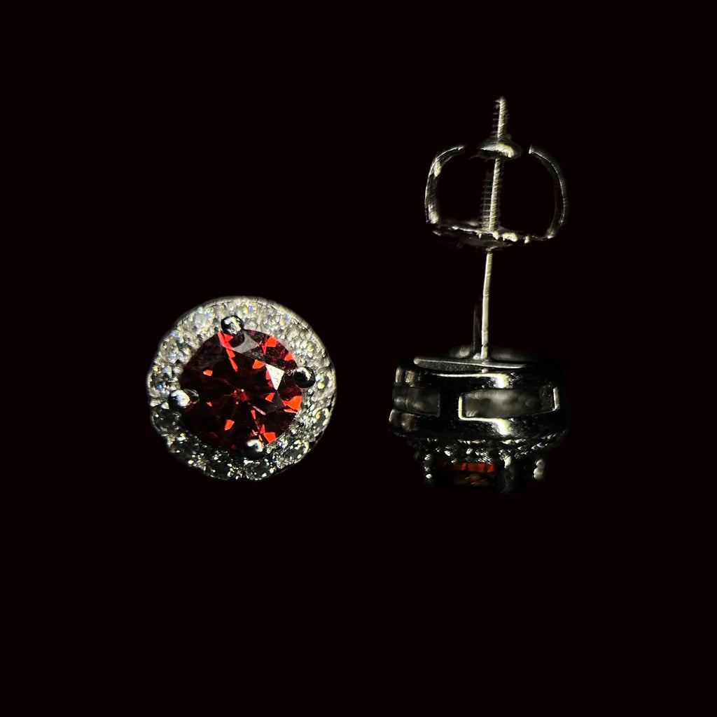 Silver earrings with red gemstones on a black background