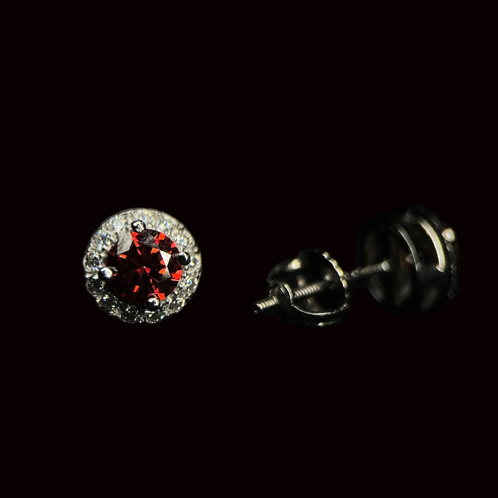 Silver earrings with a red gemstone on a black background