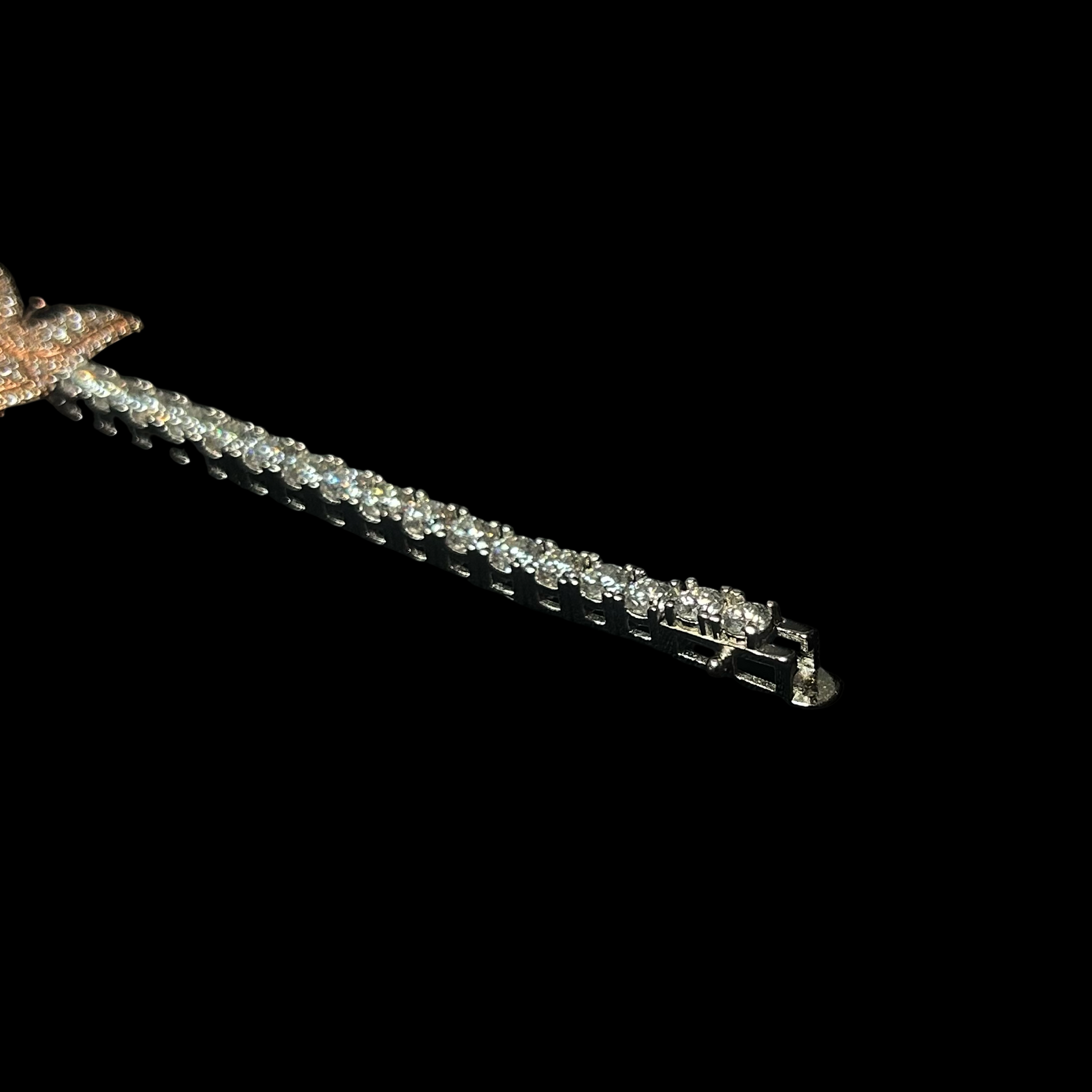 Silver bracelet with star-shaped clasp on a black background, branded 'CRUDDA'.