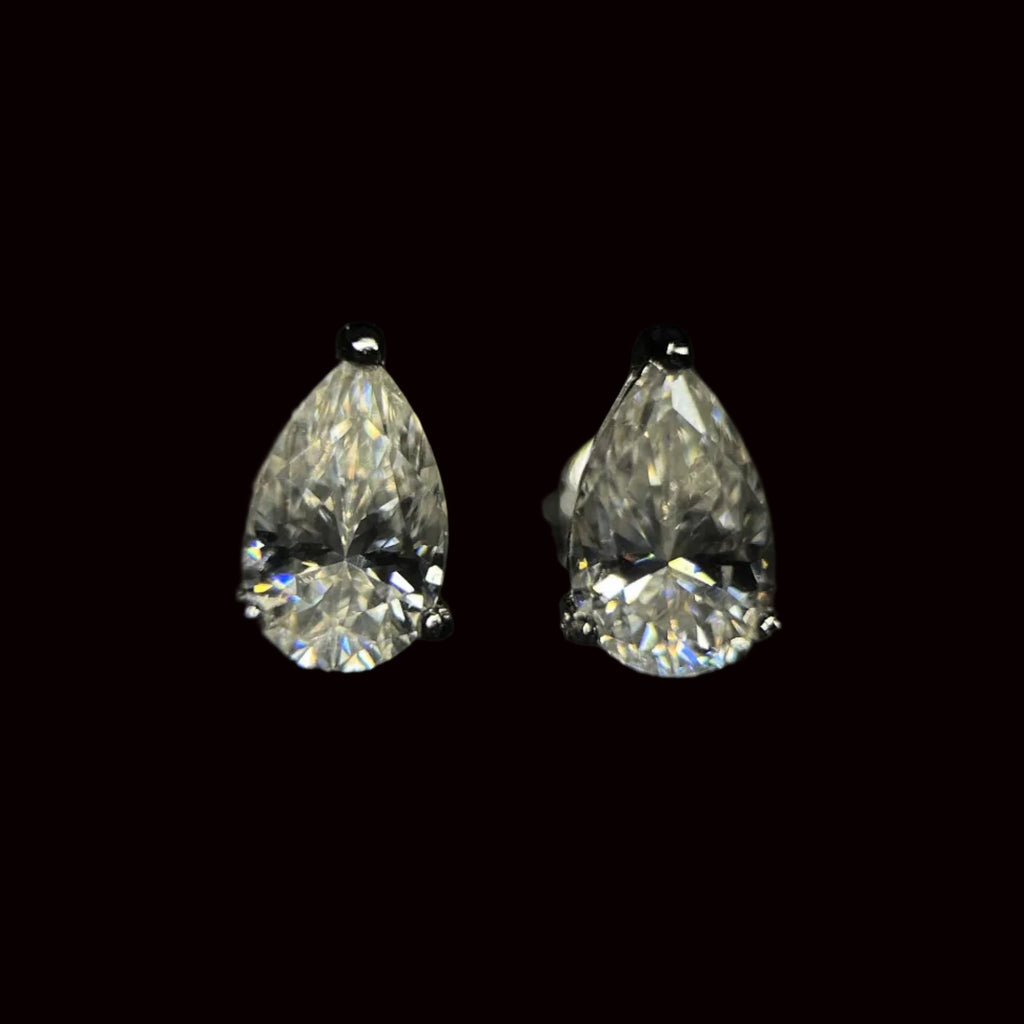 Pair of pear-shaped diamond earrings on a black background