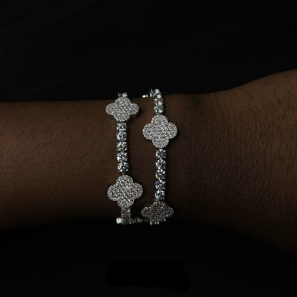 Silver hoop earrings on a wrist with 'CRUDDA.' branding.
