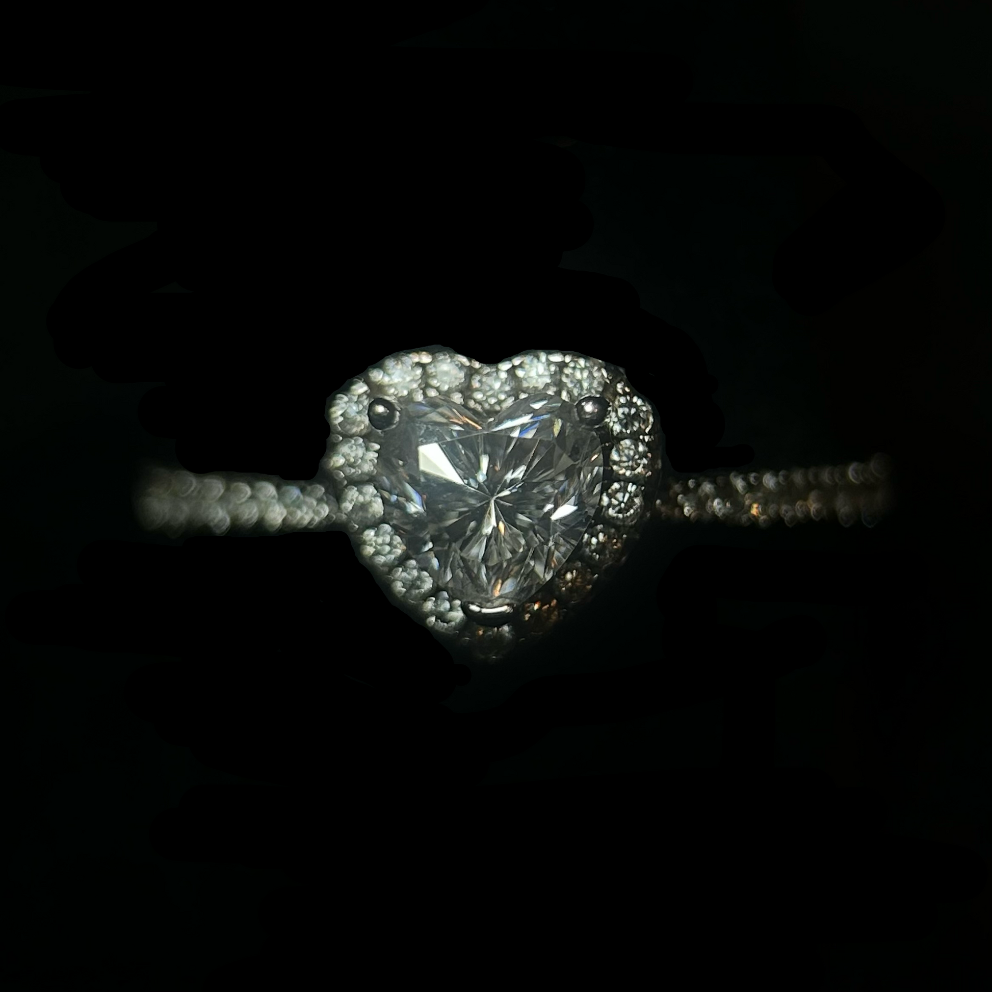 Heart-shaped diamond ring with 'CRUDDA.' branding on a black background